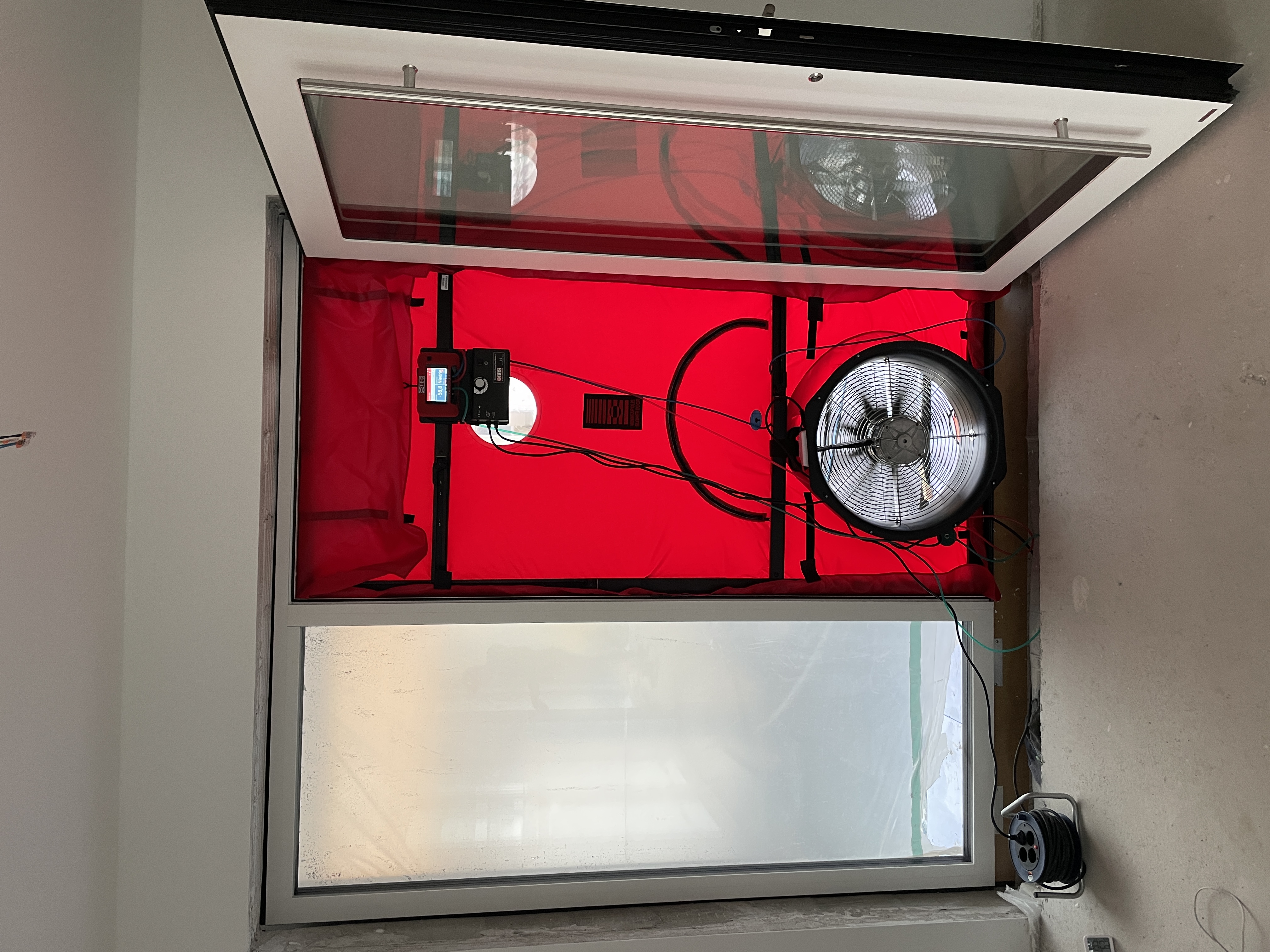 BlowerDoor Messausrüstung - Professionelle Luftdichtheitsmessung mit rotem Ventilator